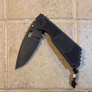 Strider knives. SMF Black textured grip with flag inlay. Magnacut blade.